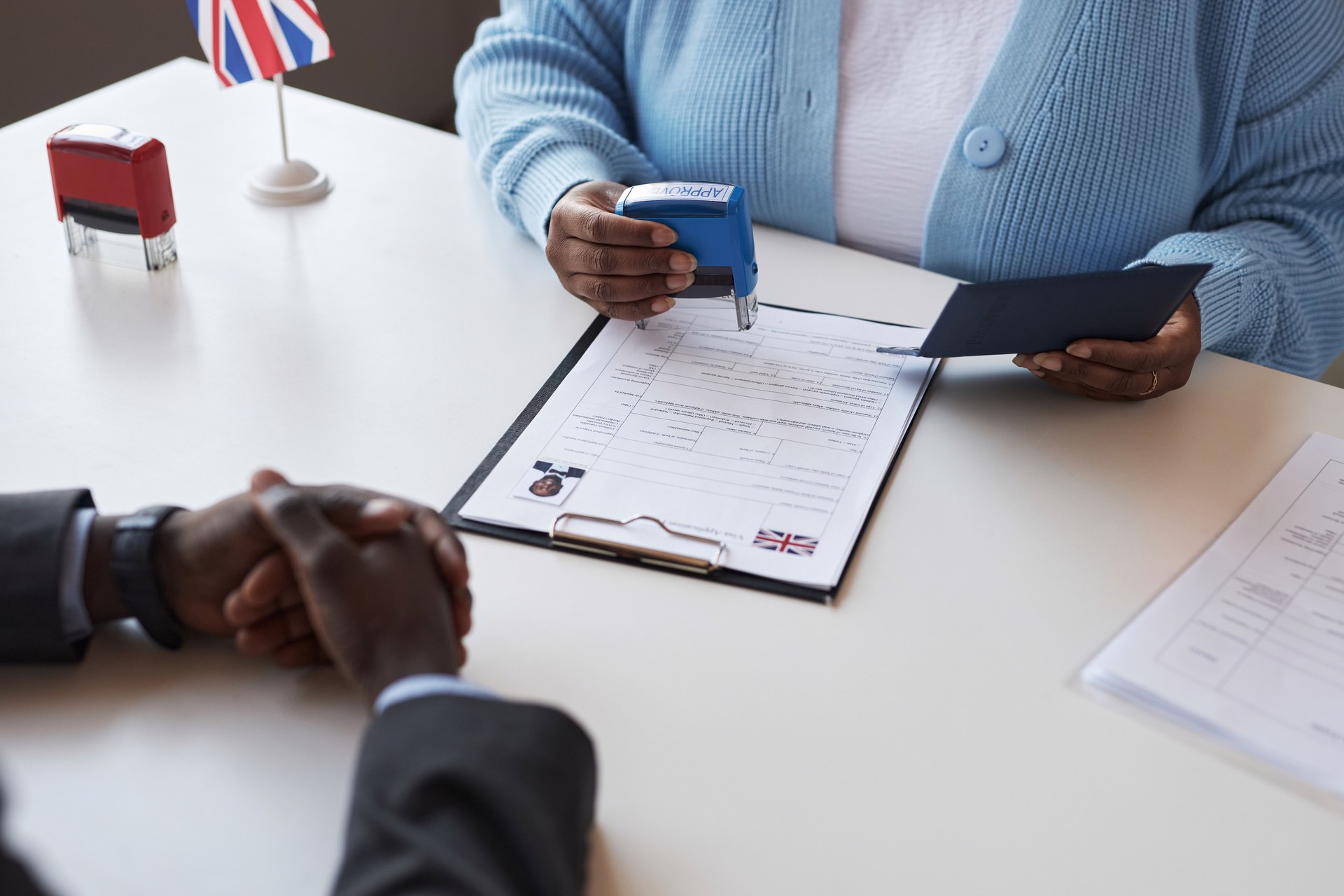 Hands of young African American woman stamping approved document