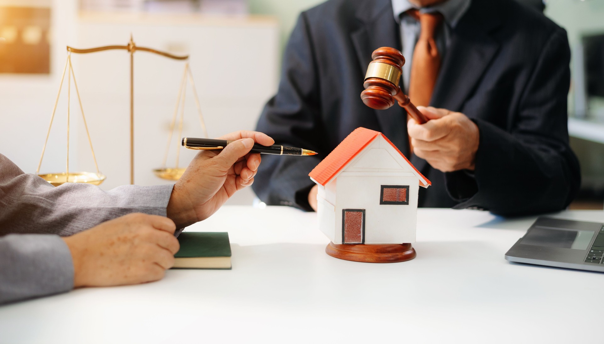 Lawyer handling house foreclosure law with gavel and home model. Legal decision, bankruptcy, and property rights concept.